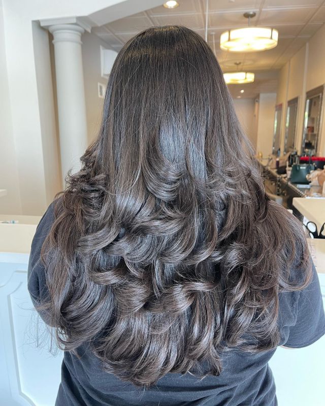 Glossy brunette blowout with soft curls
